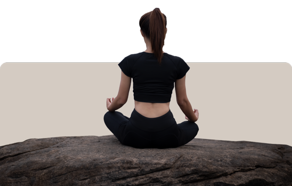 Woman sitting in a meditation pose on a rock