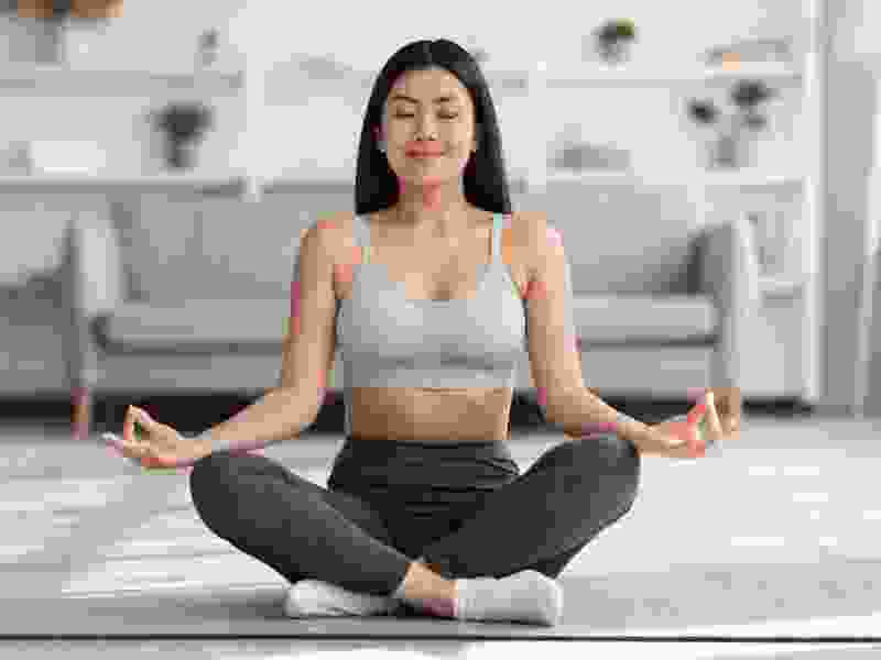 Woman meditating in a cross-legged position with eyes closed